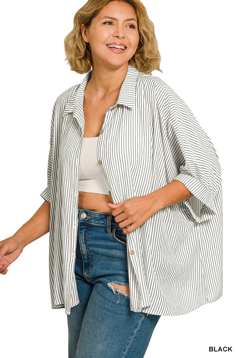 Woman in a relaxed-fit black and white striped shirt, white tank top, and blue jeans