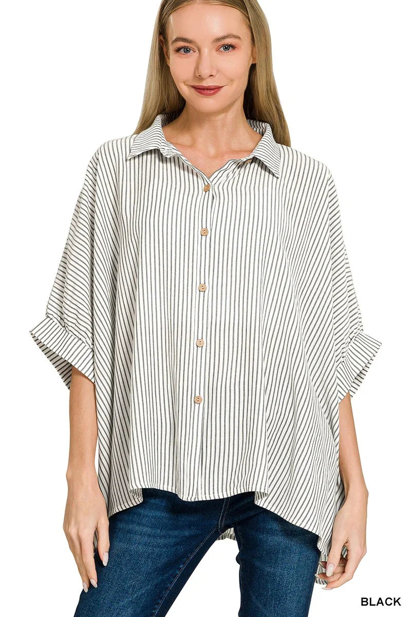 Woman wearing a relaxed black and white striped button-up shirt with wide sleeves