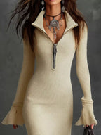 Beige ribbed knit bodycon dress with zip collar, flared sleeves, and statement jewelry.