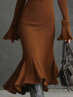 Brown ribbed knit midi dress with flared cuffs and ruffled hem, styled with black boots
