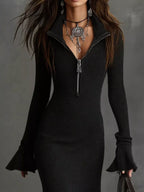 Woman wearing black ribbed zip collar knit dress with flared sleeves and layered jewelry