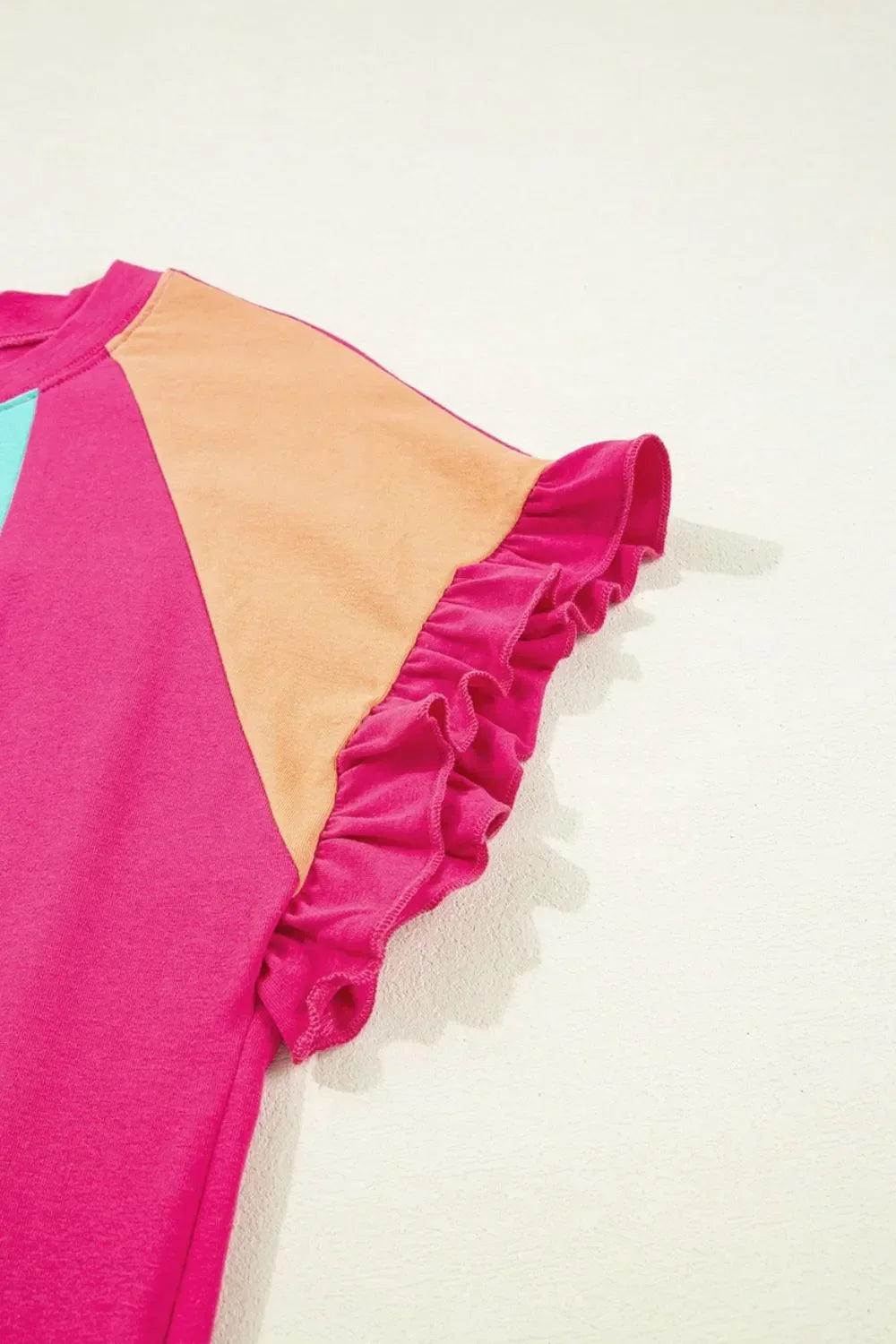 Colorblock t-shirt with pink ruffle sleeve, peach shoulder panel, and blue accent