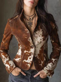 Woman wearing a brown and white cowhide print fitted jacket with layered necklaces
