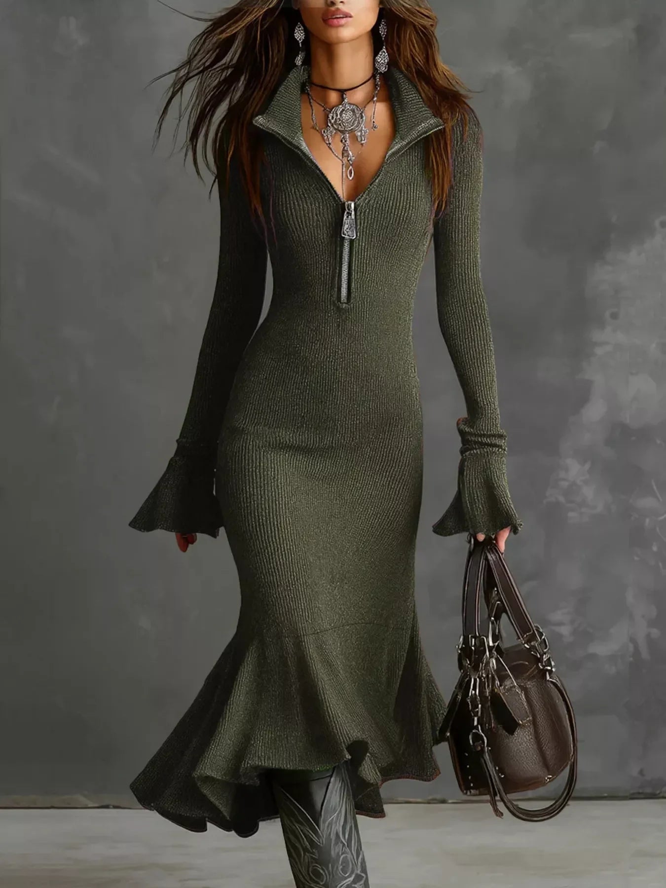 Woman in a fitted olive knit midi dress with zip collar, flared cuffs, ruffled hem, holding a brown handbag.