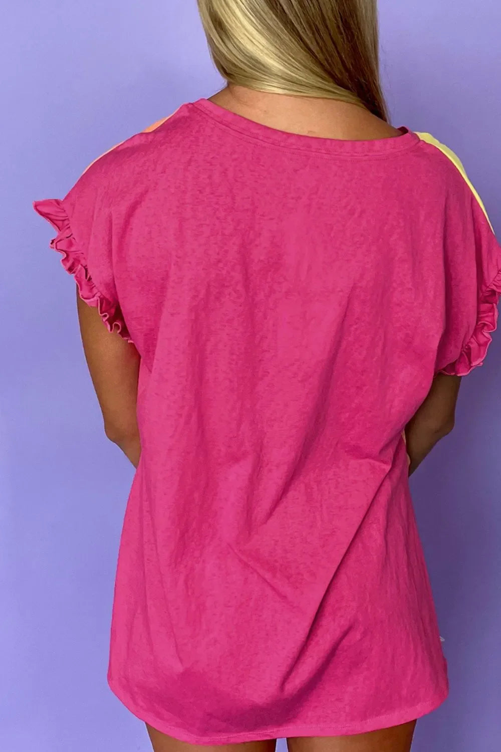 Back view of woman wearing pink ruffle sleeve oversized t-shirt dress against purple background