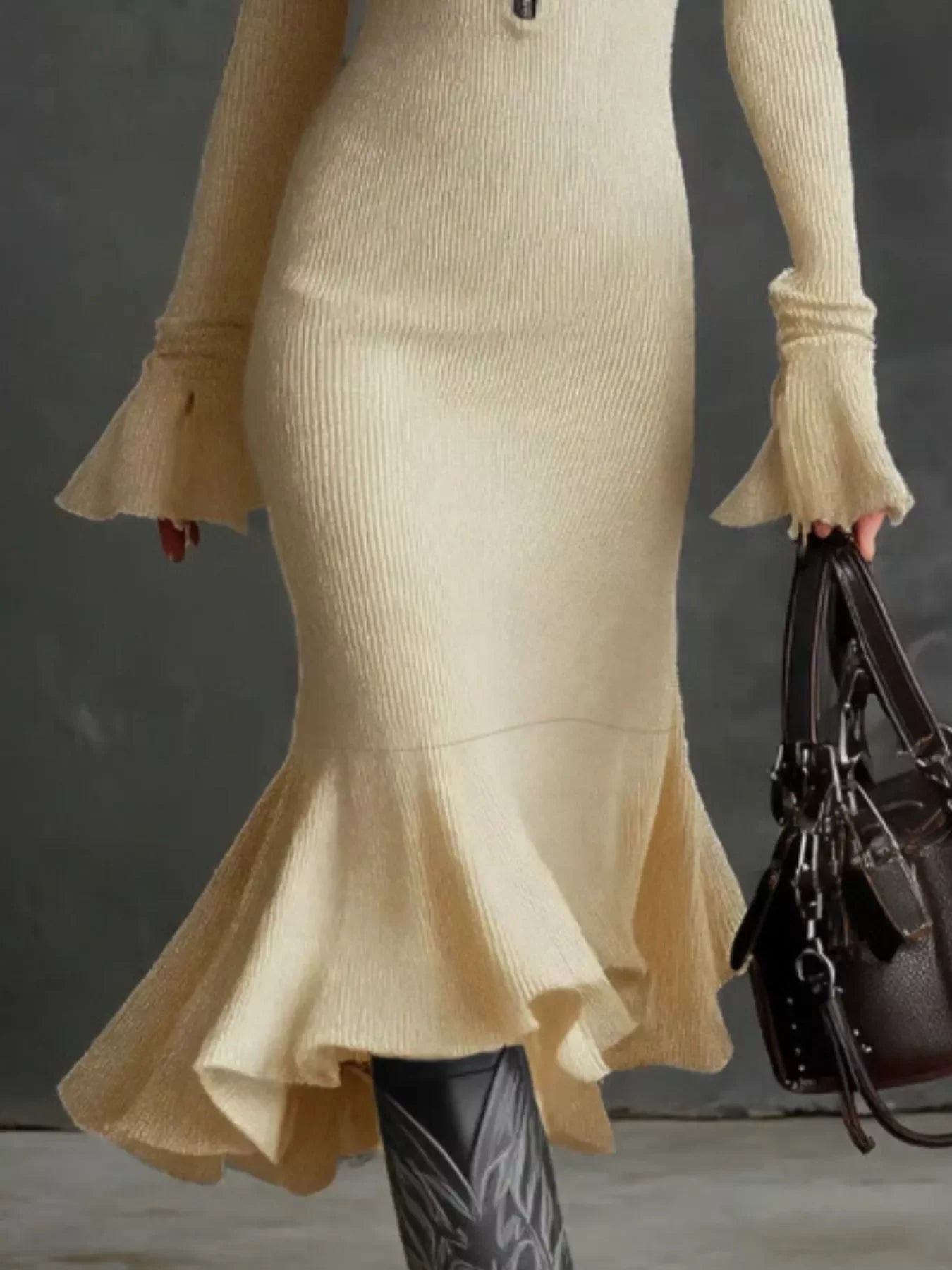 Beige ribbed knit midi dress with flared sleeves and ruffled hem, paired with black boots