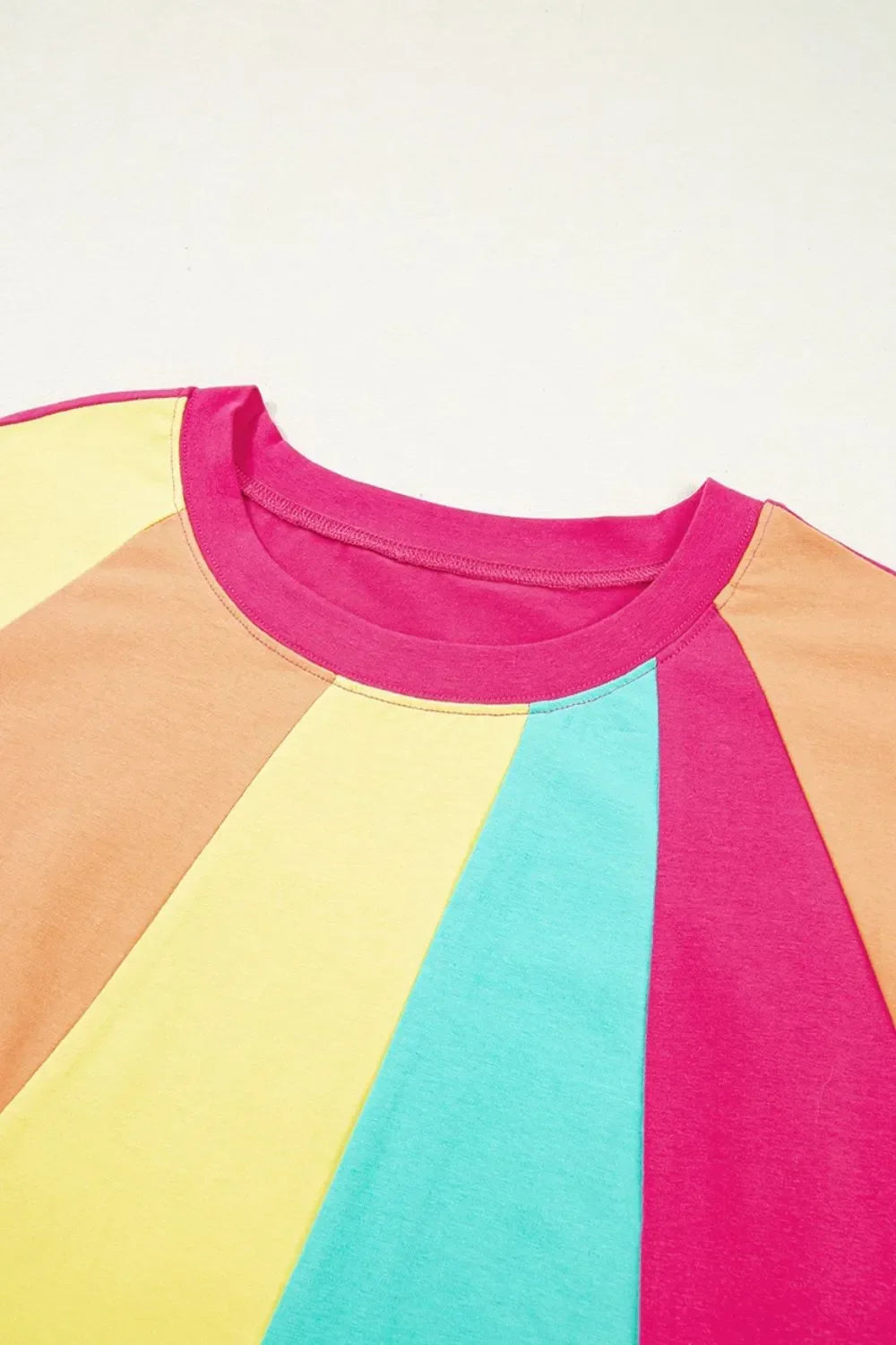 Colorblock short sleeve top with pink, blue, yellow and tan panels, round neckline