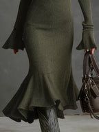 Metallic green ribbed midi dress with flared cuffs and hem, paired with black boots and bag