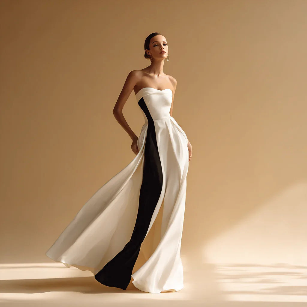 Elegant woman in strapless black and white evening gown, flowing fabric, minimalist studio